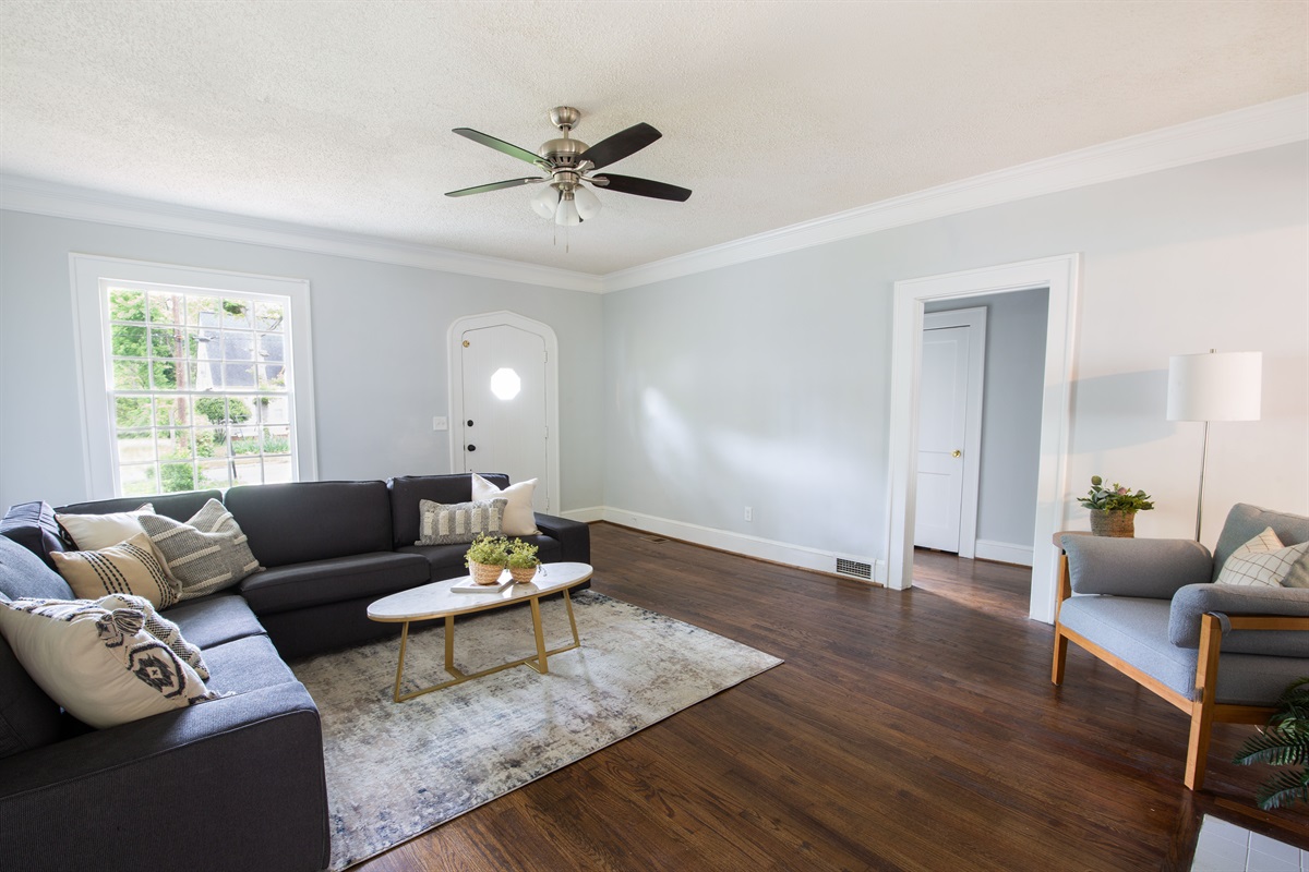 The living room features large windows with natural light. 