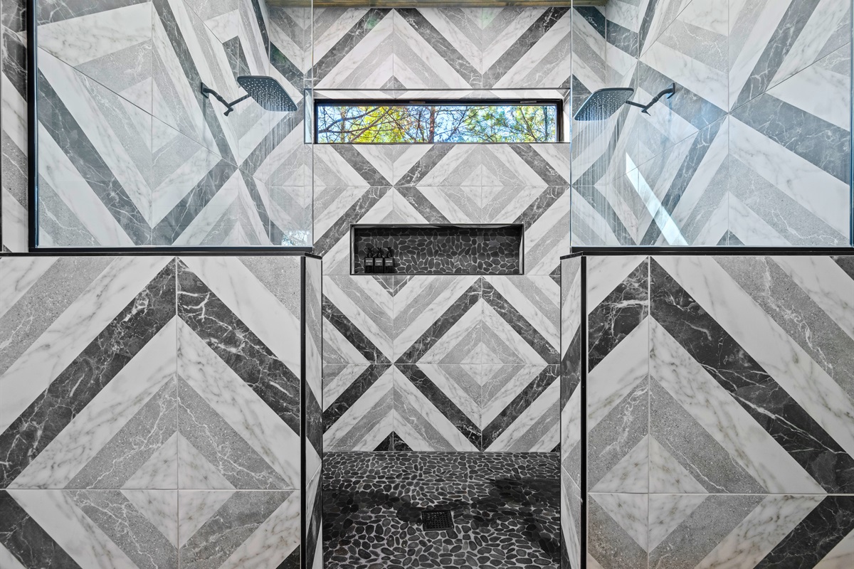 With its striking tile design and glass showers, this bathroom pairs modern flair with rustic elegance.