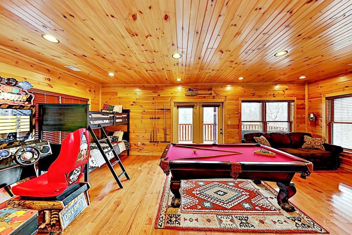 Basement game room with twin beds and queen sleeper sofa with half bathroom.