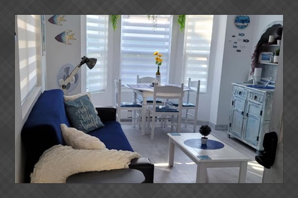 Living area with dining table for 4 guests, futon that folds in a single bed for 1 adult or 2 small children, and app TV.