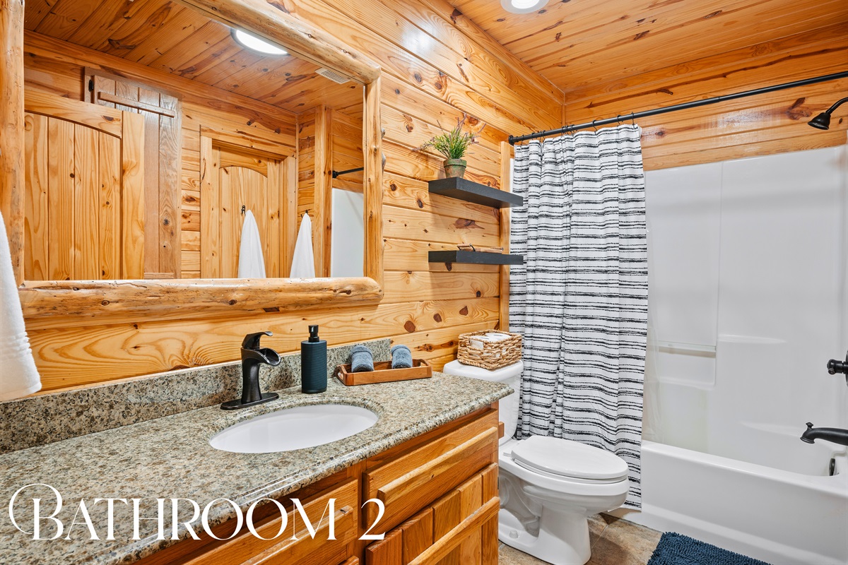 Full bathroom with granite vanity, well-lit mirror, and a shower/tub combo for added comfort and convenience.