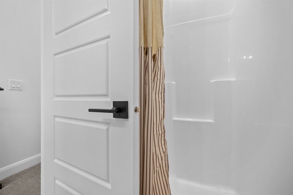 Glass-enclosed shower with neutral tile and spa-like feel.