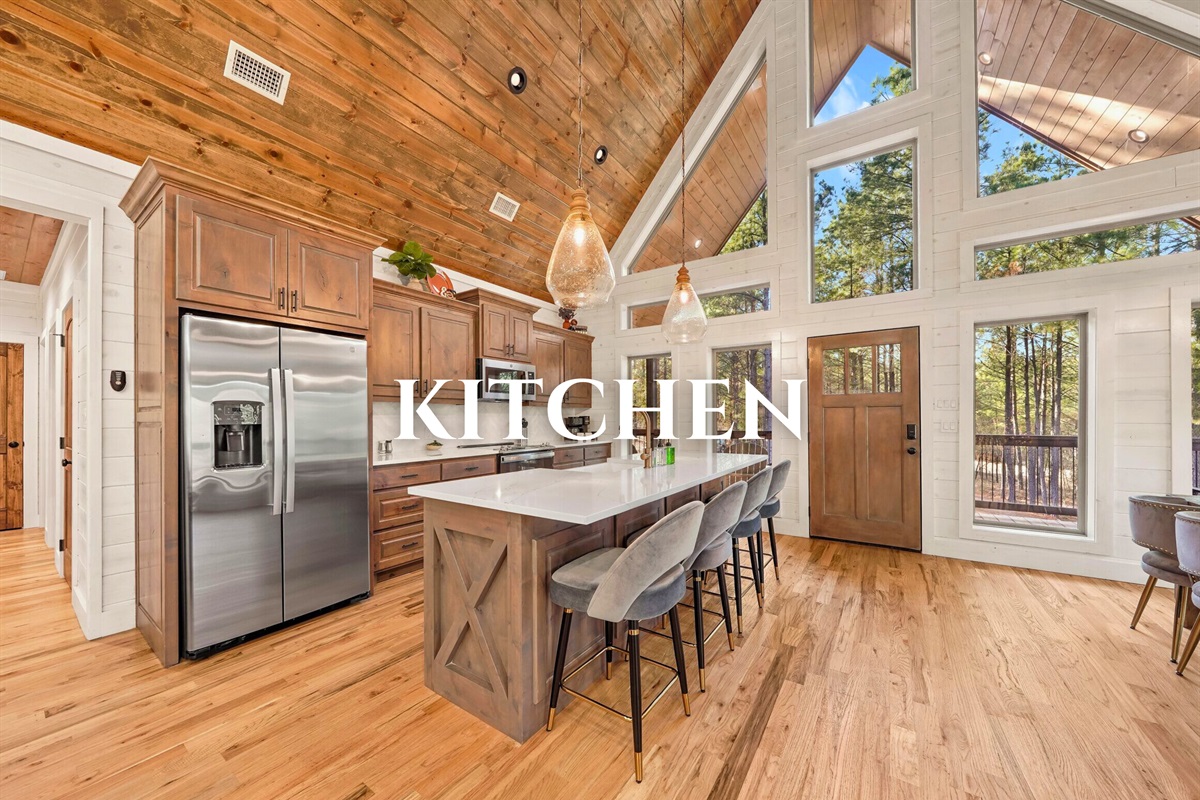 Modern kitchen with stainless appliances and wood finishes.