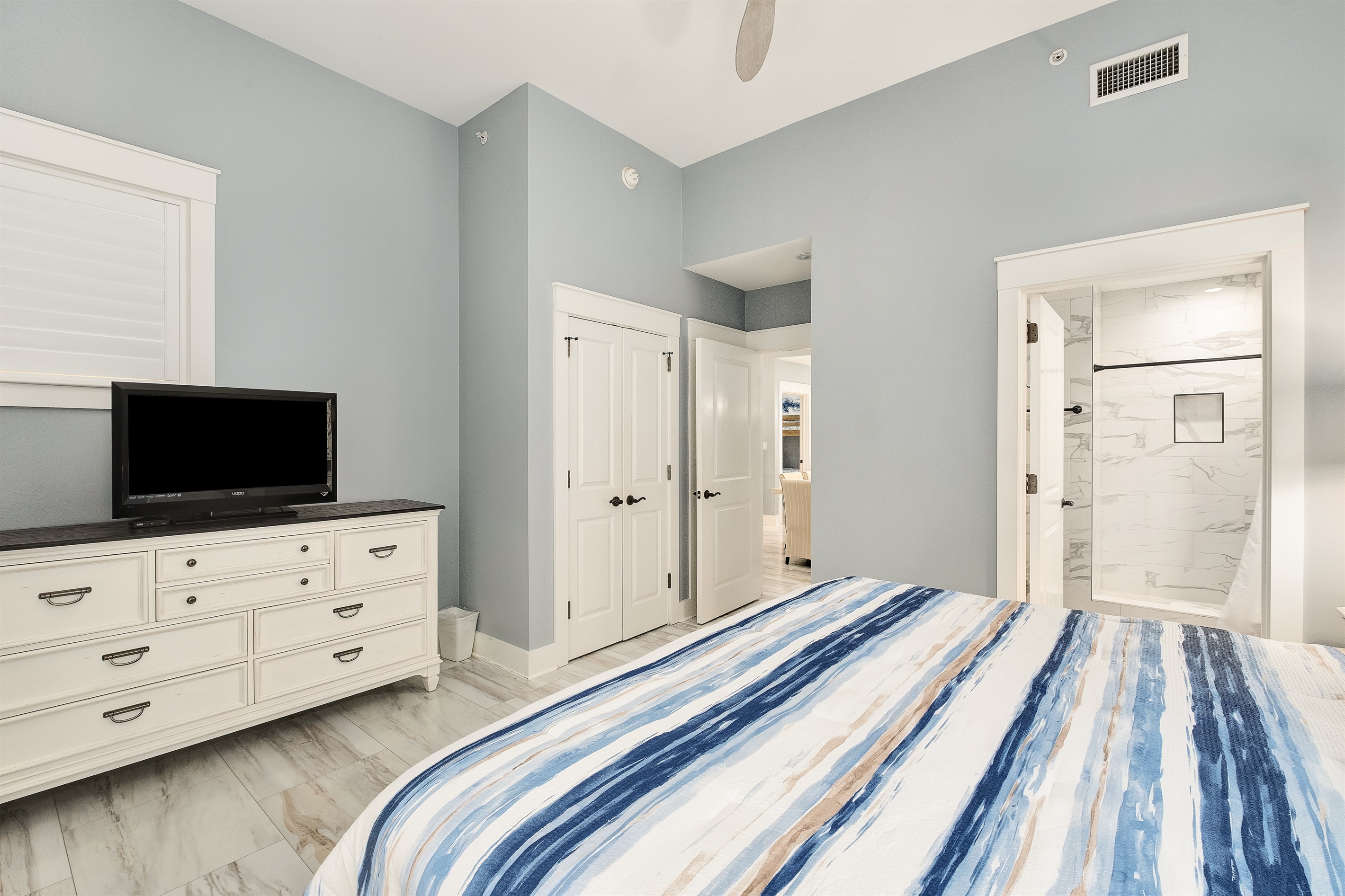 Relax in the spacious master bedroom, complete with a plush king bed and tranquil coastal decor. Perfect for unwinding after a day of adventure.