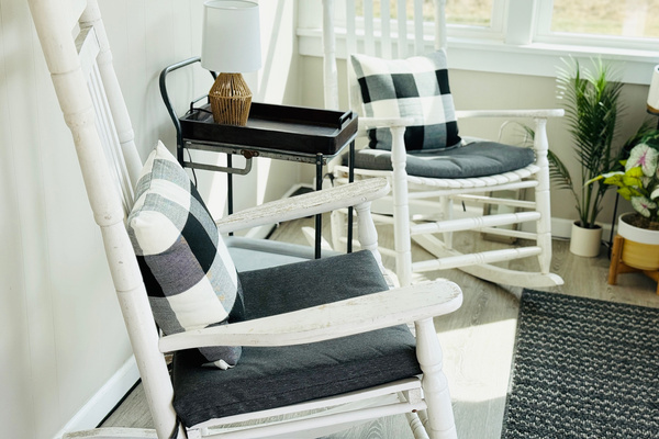 Enclosed sitting area with rocking chairs and abundant natural light.