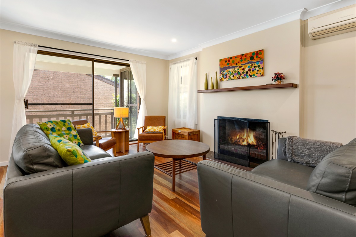 An open fireplace gives this upstairs lounge a genuine winter beach-house feel, with relaxed seating around the hearth at Bertie’s 3 Beaches.