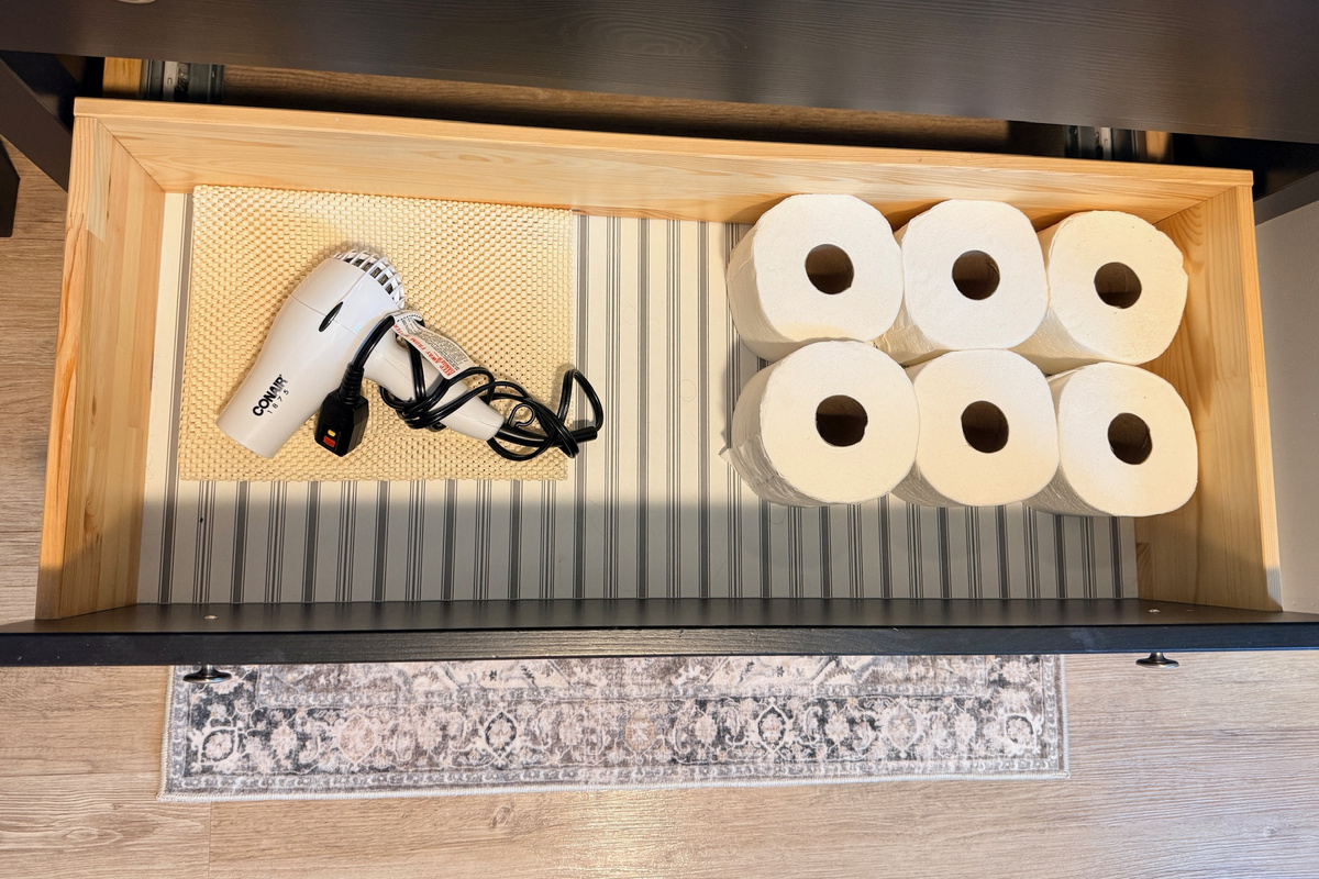 Extra toilet paper and basic supplies are kept within easy reach.