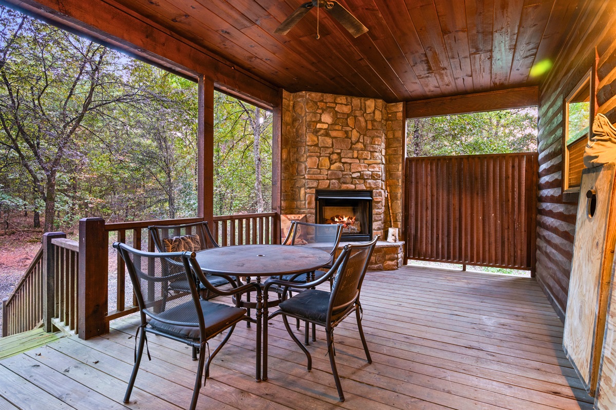 Private patio with table, fireplace, and secluded hot tub area.