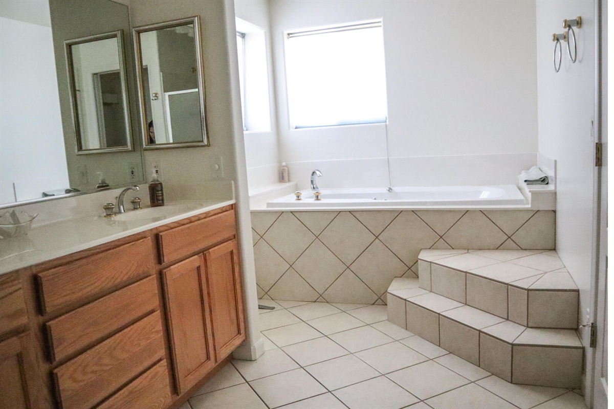 Primary en-suite bathroom with walk-in shower, jacuzzi tub and double sinks.