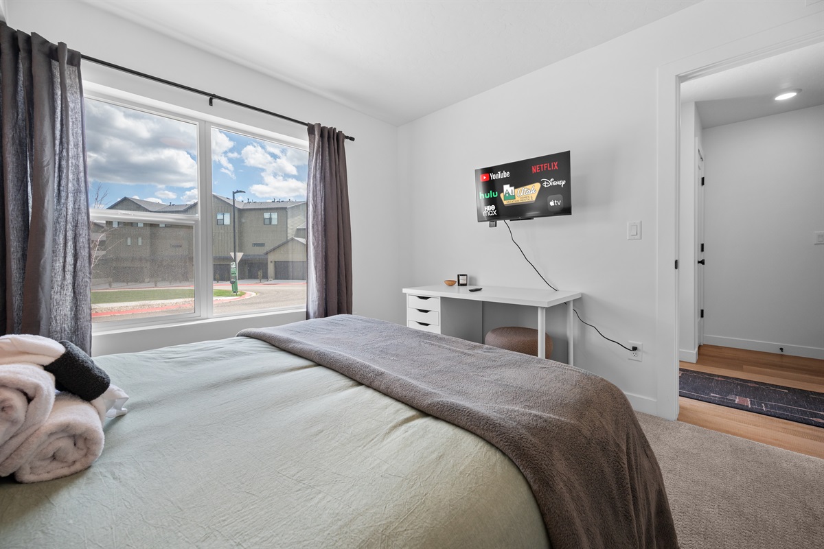 Bedroom with Smart TV and peaceful neighborhood views.