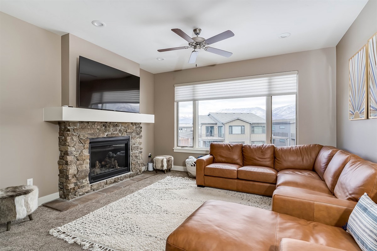 Sink into comfort with plush seating, fireplace warmth, and a large TV