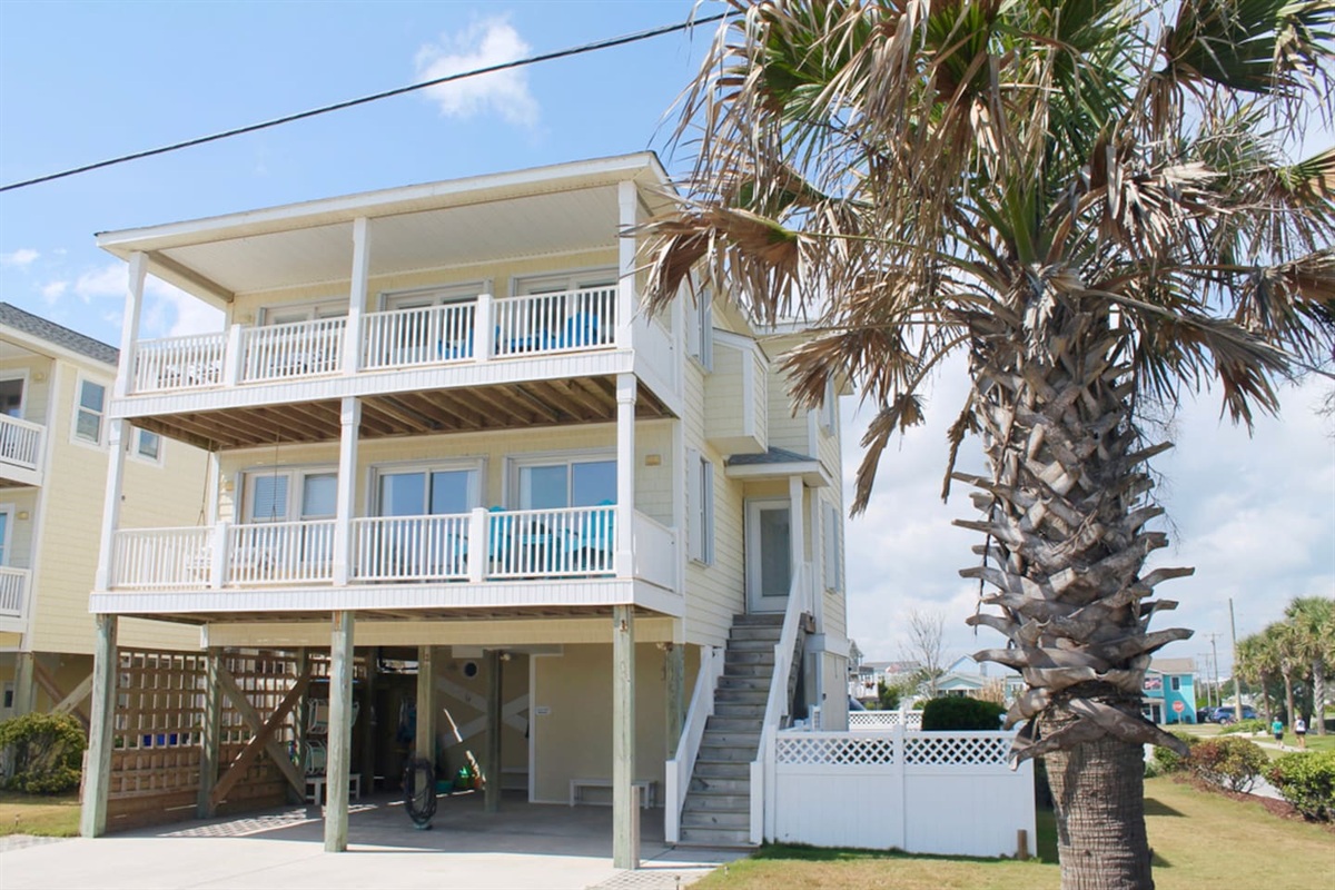 Exterior, front of house. Parking for 6. Entry to outdoor showers on left side of carport. Access to basement bedroom and elevator in carport. 