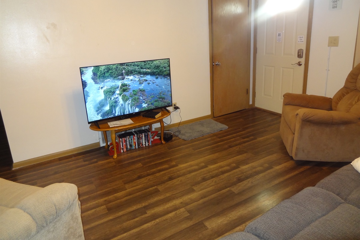Living room with 2 recliners, reclining couch and Roku smart TV