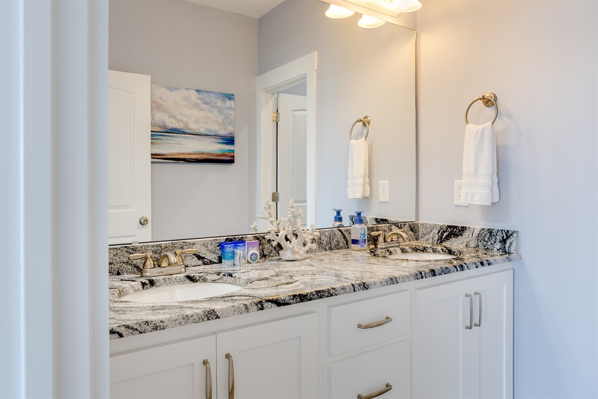 Clean coastal design with a wide mirror, dual sinks, and thoughtful details throughout