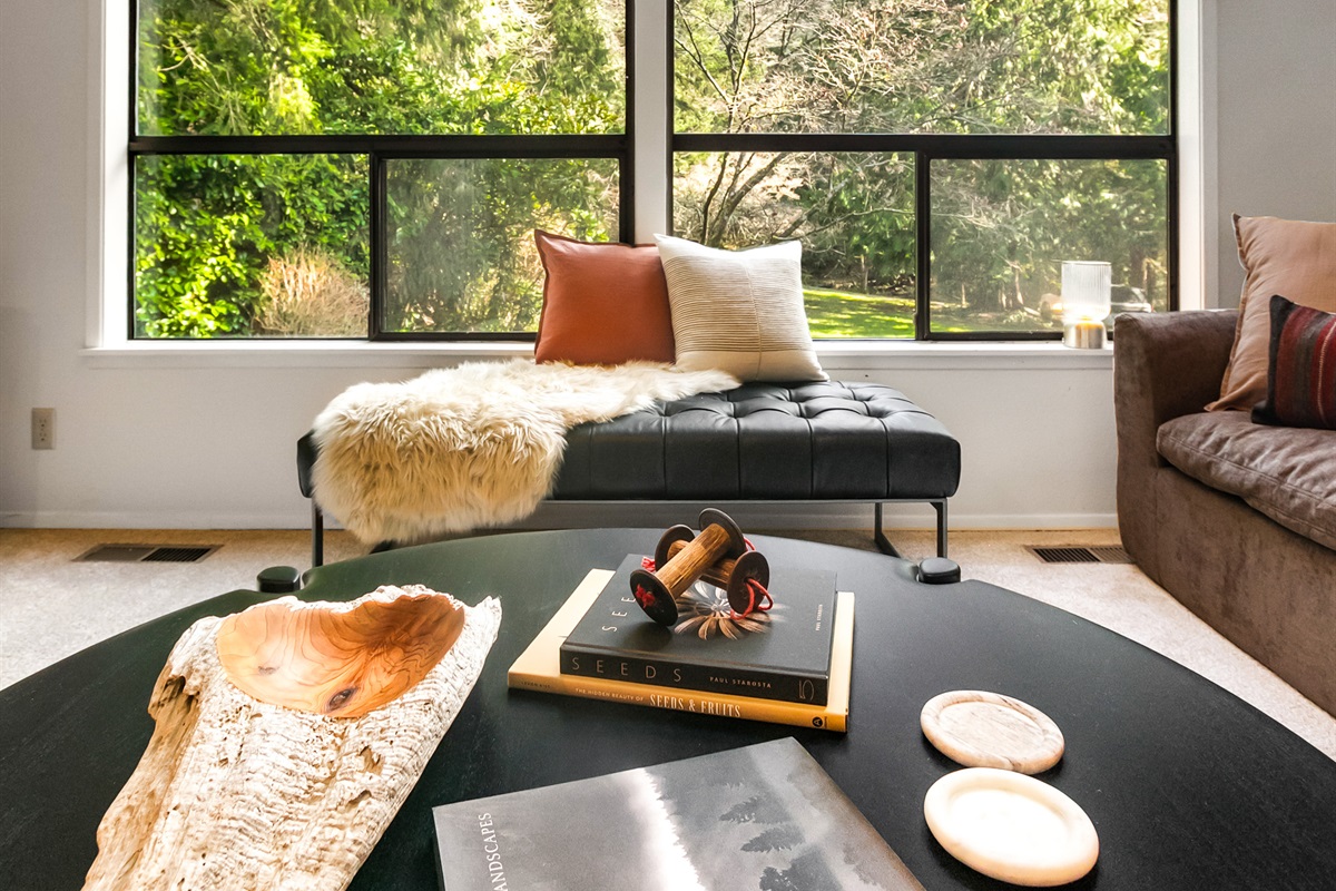 A large round coffee table in the living room is the perfect stage for your charcuterie and cheese plate. Play games or share snacks while enjoying the forest view.