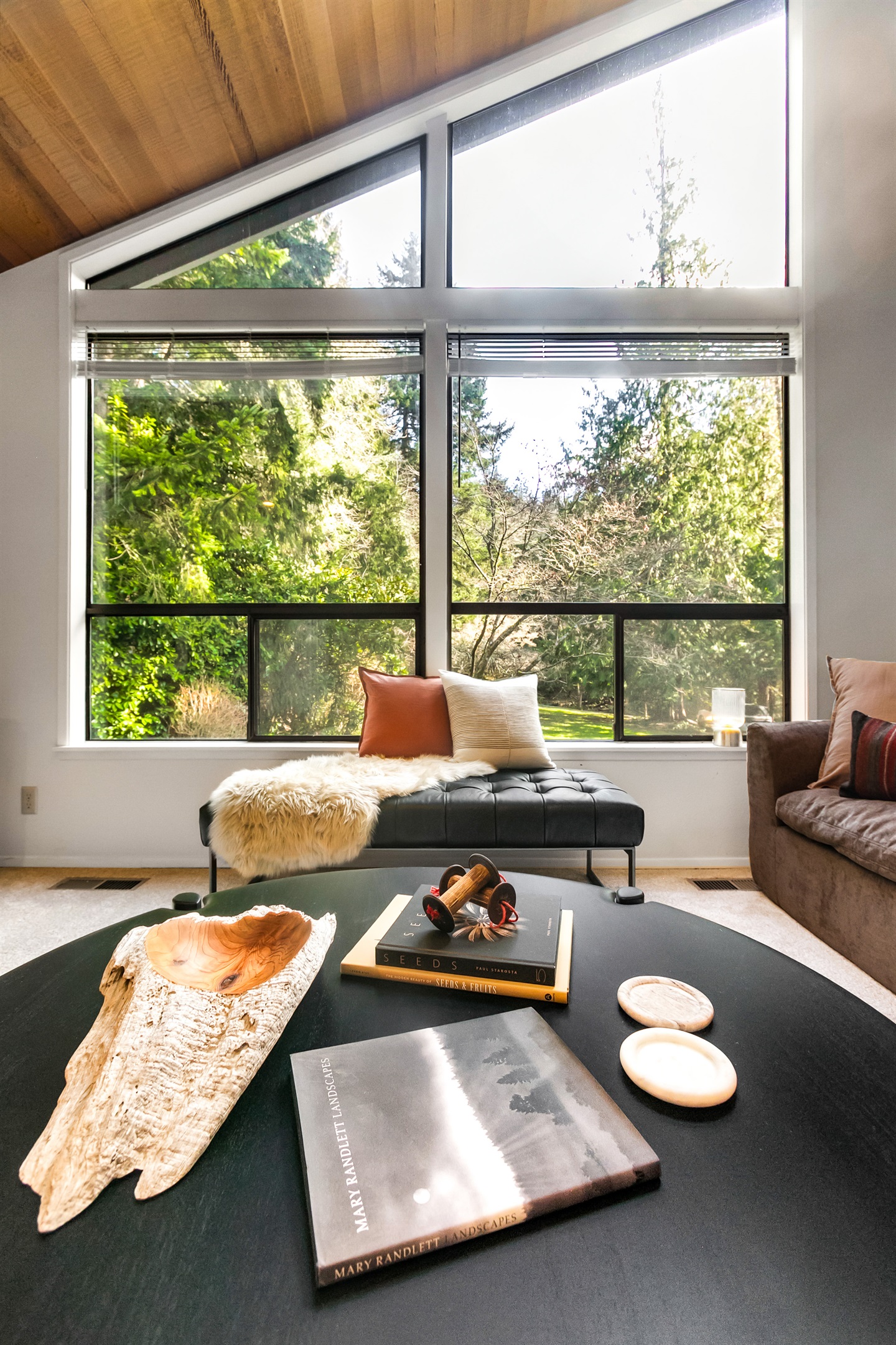 A large round coffee table in the living room is the perfect stage for your charcuterie and cheese plate. Play games or share snacks while enjoying the forest view.