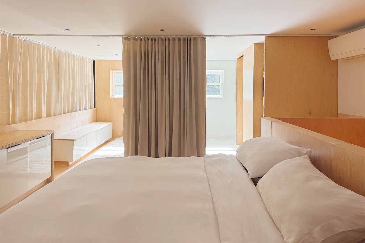 Upstairs loft bedroom with king sized bed, dedicated desk space, walk-in closet and en suite bathroom with private toilet room.