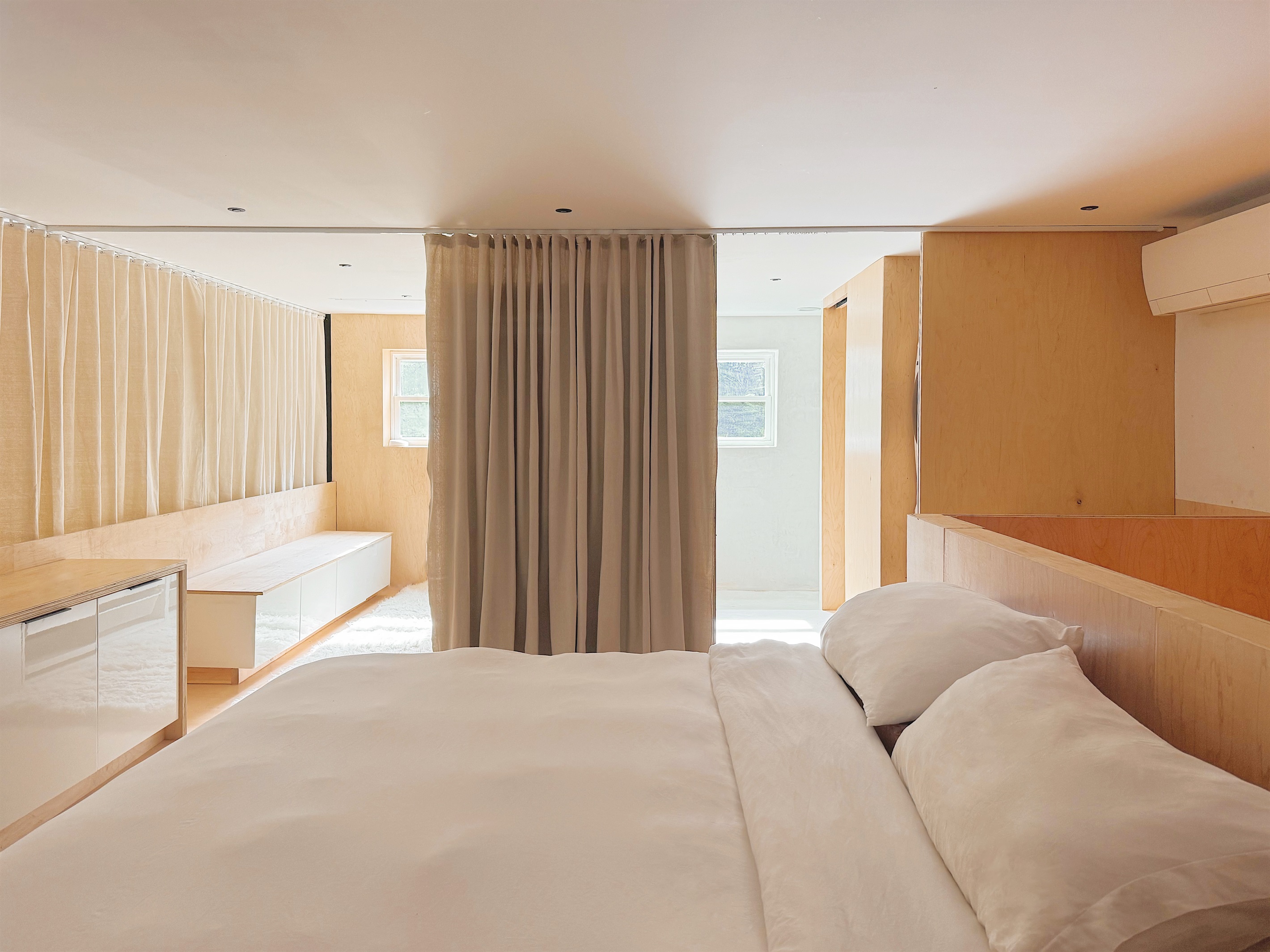 Upstairs loft bedroom with king sized bed, dedicated desk space, walk-in closet and en suite bathroom with private toilet room.