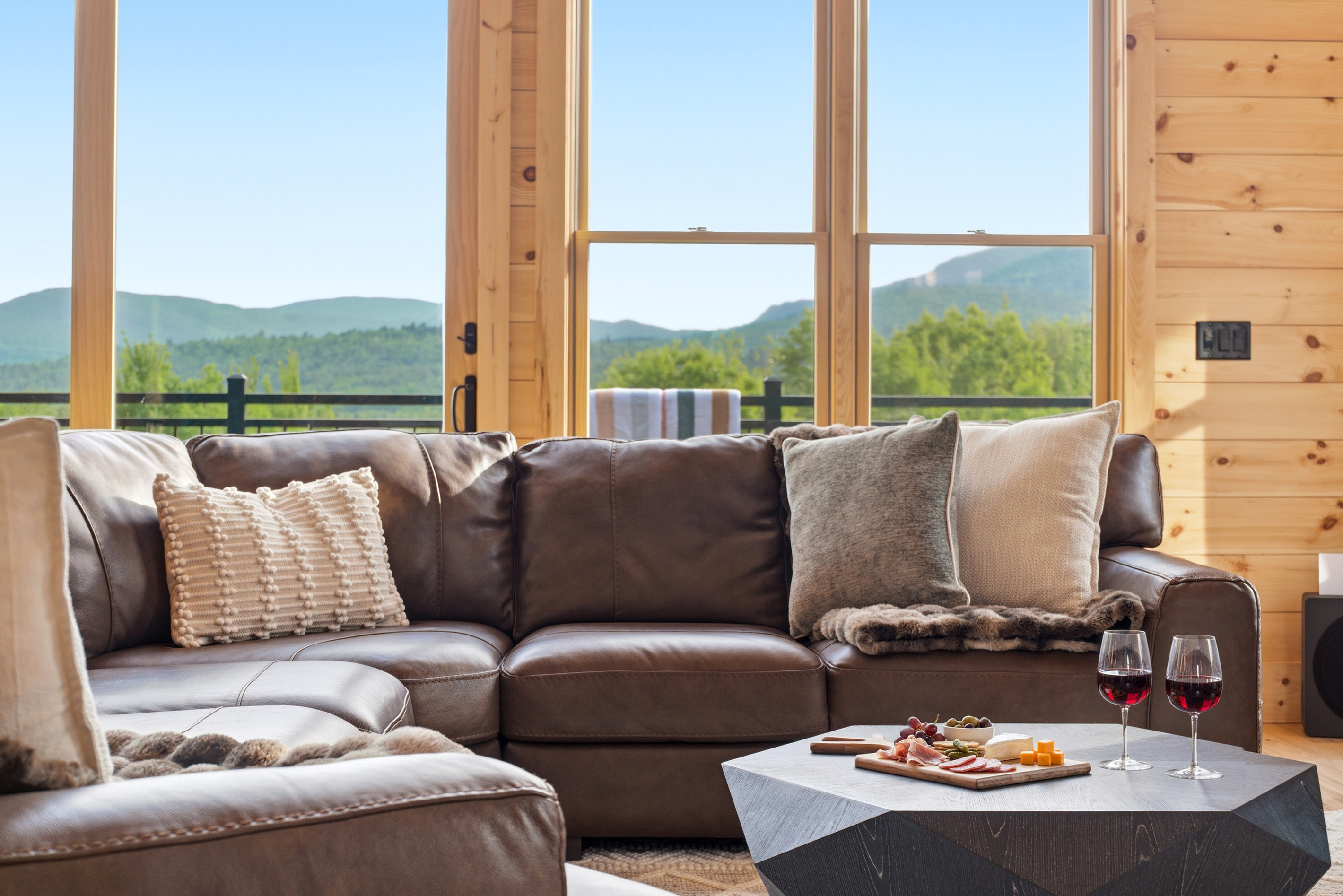 Sip, snack, and unwind on the comfortable sectional surrounded by peaceful mountain scenery.