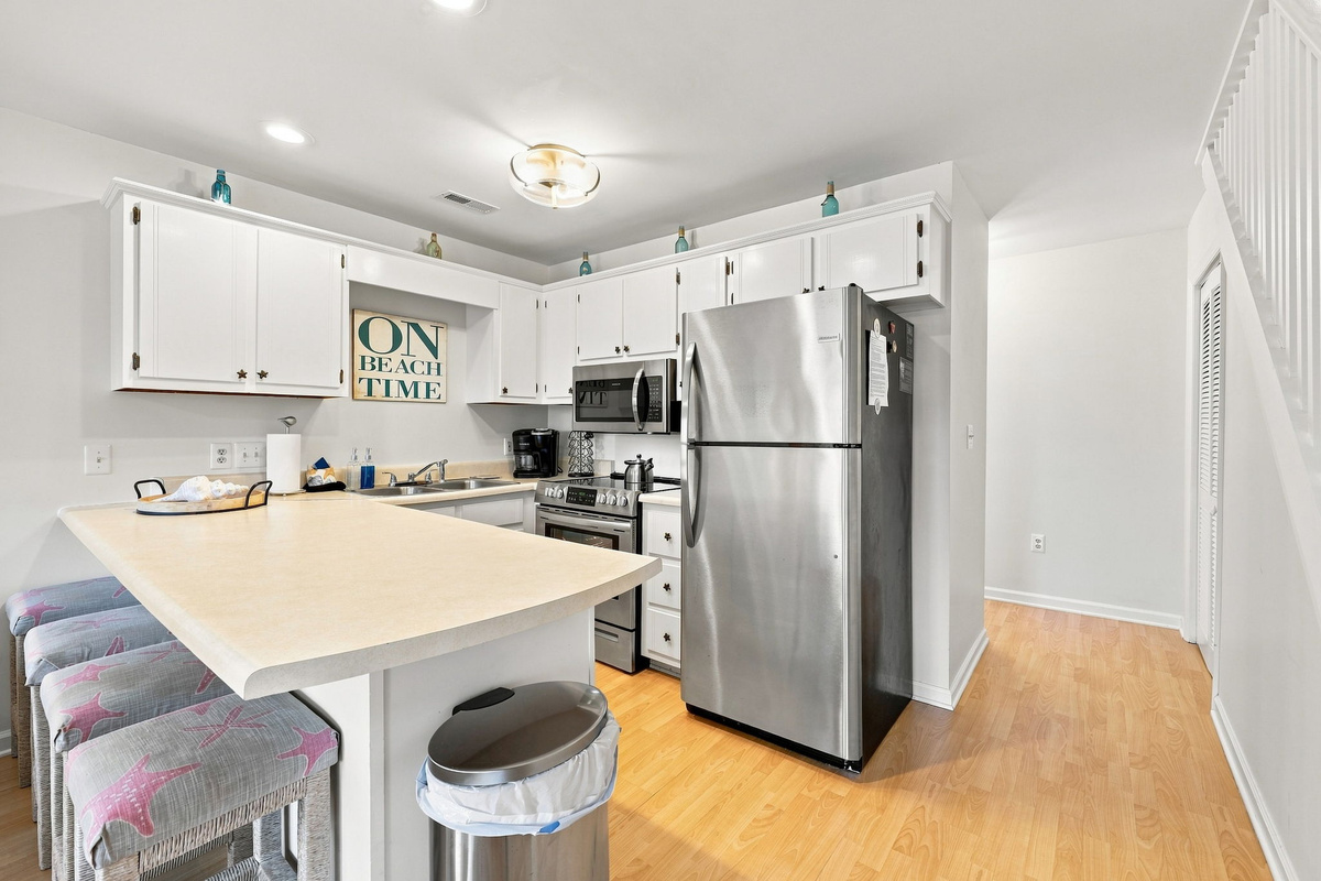 Grab a quick bite at the breakfast bar or prep snacks for the beach in this bright, functional kitchen space.