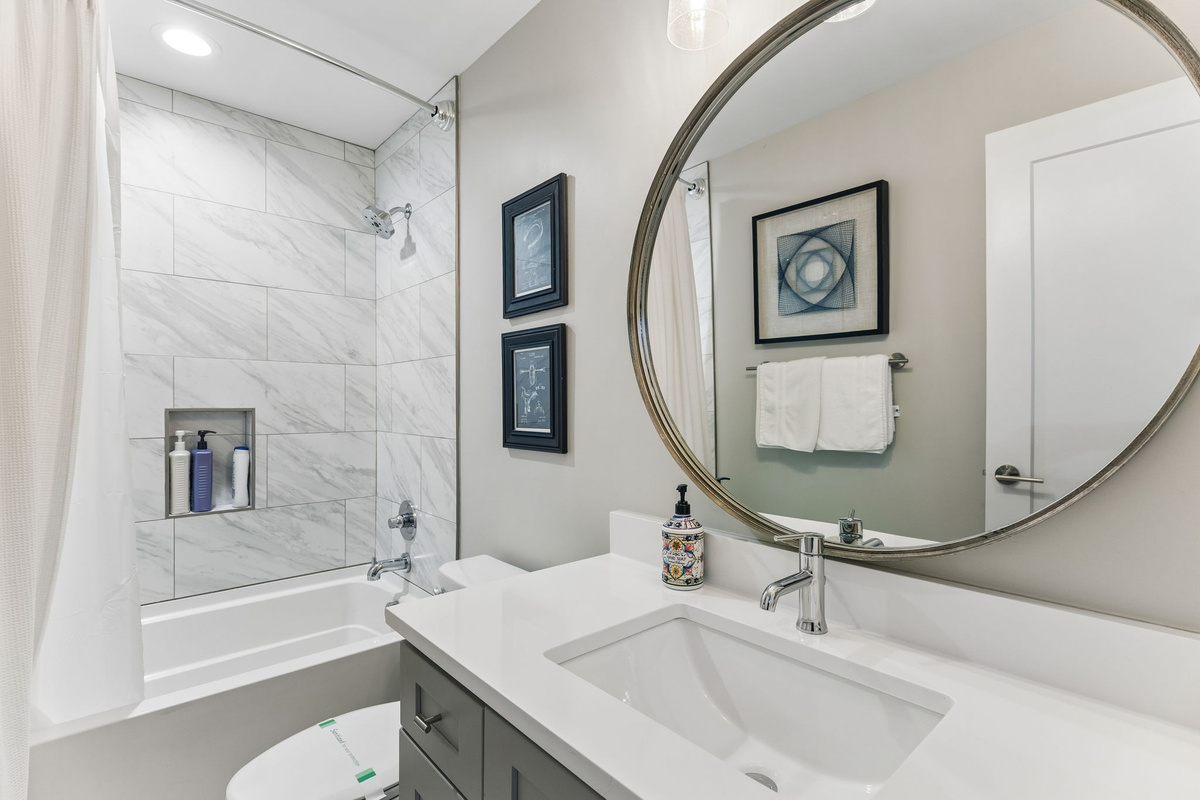 Soak in the tub or take a fast shower &mdash; the full bathroom gives you options with a marble-look combo, hex floors, and a clean, hotel-grade finish.