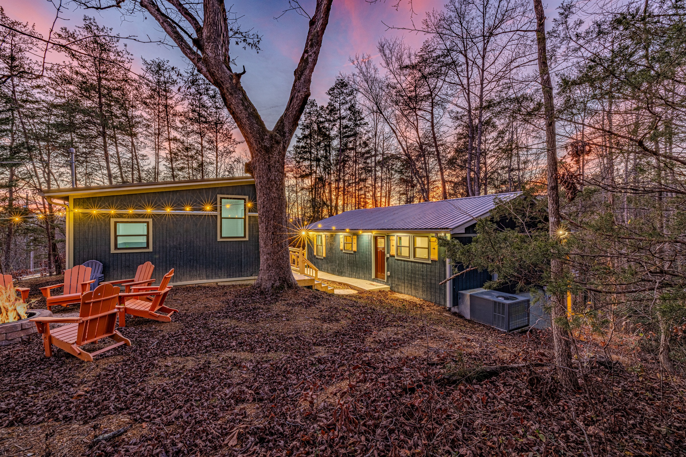 Unwind by the crackling fire pit at Mid Mod Mountain Bliss as the sun sets behind the towering pines.