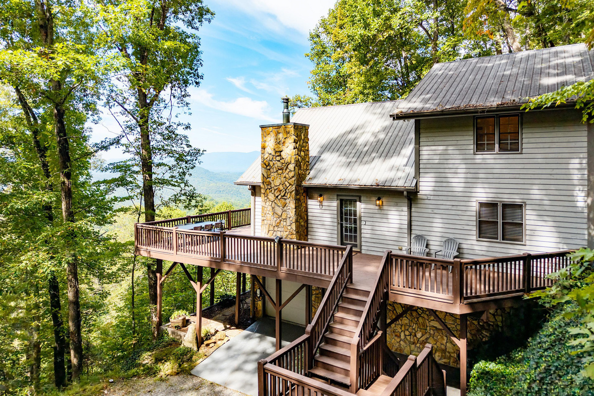 Take in the stunning mountain views from this side profile of the cabin, offering a perfect welcome before you step inside and a beautiful sight as you hea