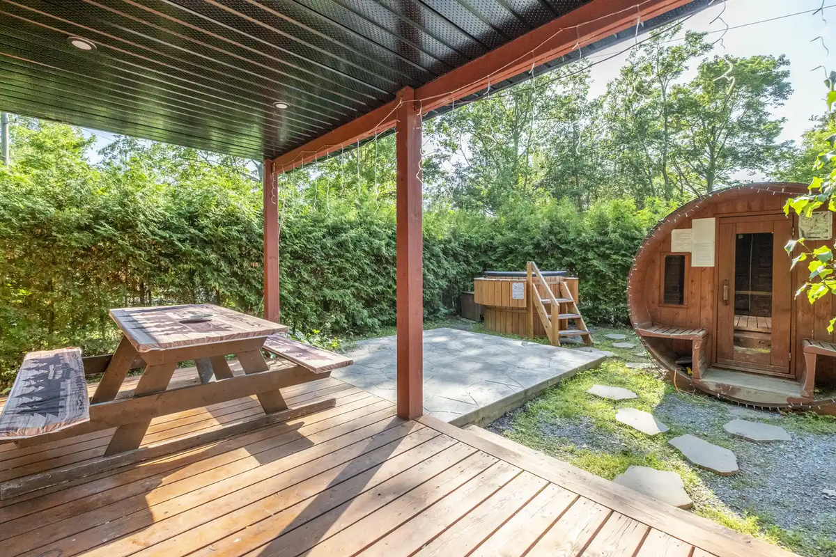 Covered porch with outdoor seating and private sauna view