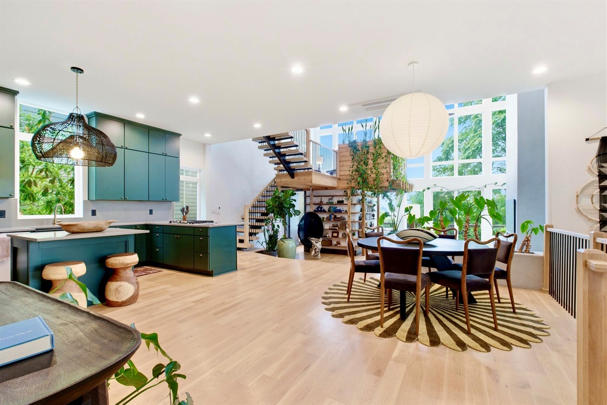 Sun-filled open-plan dining & kitchen w/ sleek teal cabinetry & room for the whole group.
