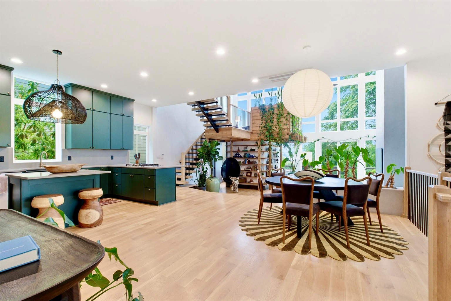 Sun-filled open-plan dining & kitchen w/ sleek teal cabinetry & room for the whole group.
