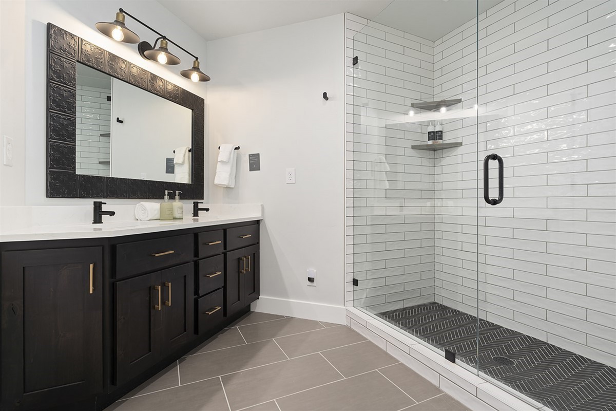 A beautifully appointed bathroom with a sleek double vanity and elegant walk-in shower offers a spa-like experience with refined finishes.