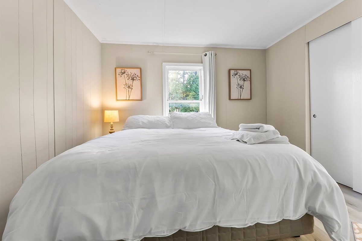 Cozy bed with crisp white linens and soft lighting for restful nights.