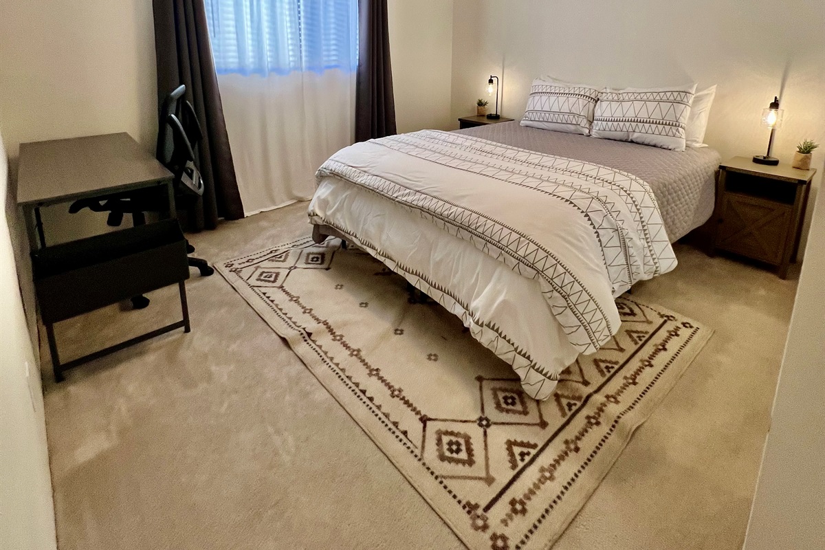 Whether you need to work or unwind, this third bedroom has you covered.  The dedicated workspace with a desk and comfortable chair provides a productive environment, while the plush queen-size bed ensures a restful night's sleep.