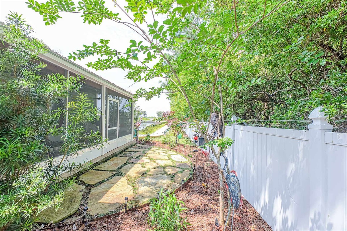 Outdoor Serenity: Explore the lush garden path leading to tranquil waterside views!