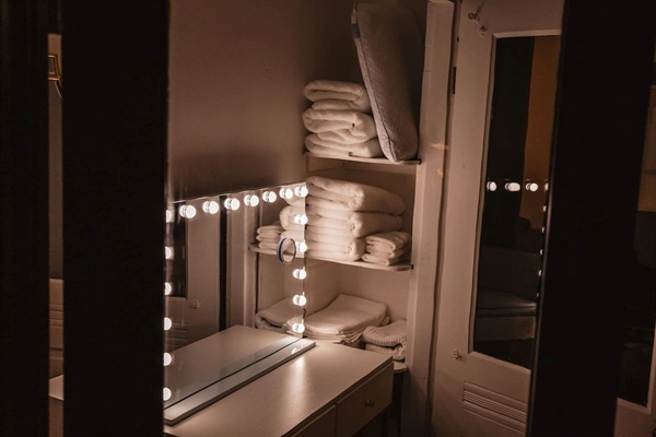 Mirrored vanity with blue tooth. Plenty of extra linens.