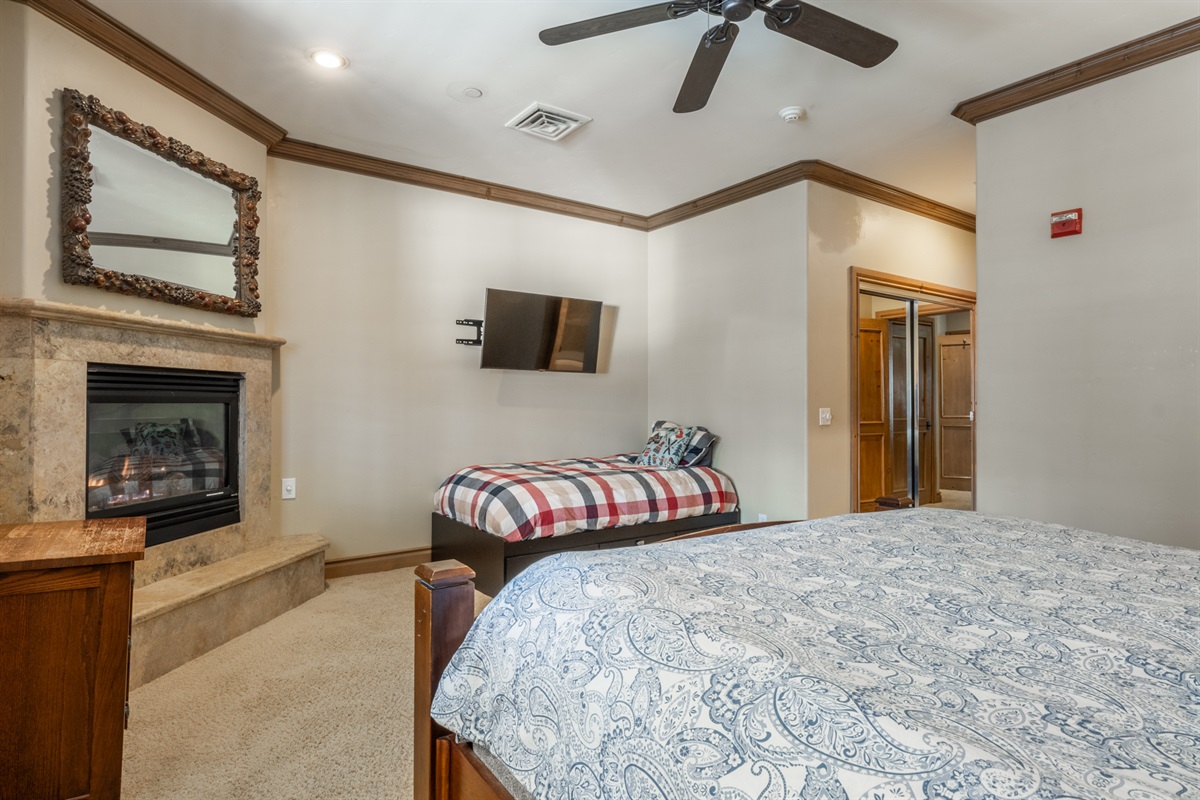 King bedroom with solid wood bed, ceiling fan, and mountain-inspired decor.