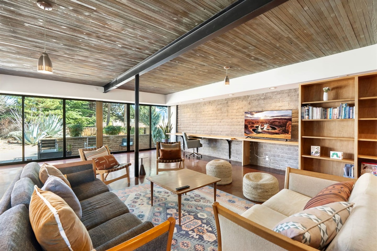 Spacious open living area with warm wood ceilings and inviting mid-century charm.