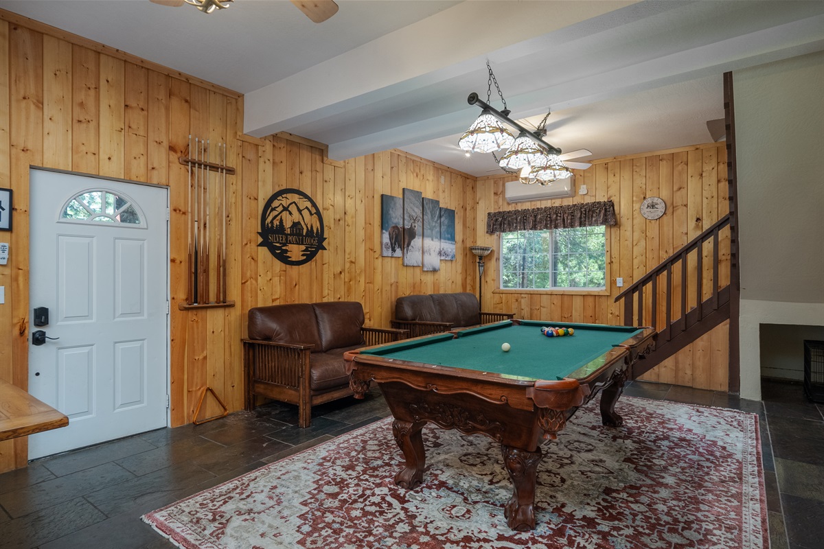 Step into cozy room with a pool table, wood fireplace, smart TV, and plenty of seating. Perfect for relaxing and entertaining.