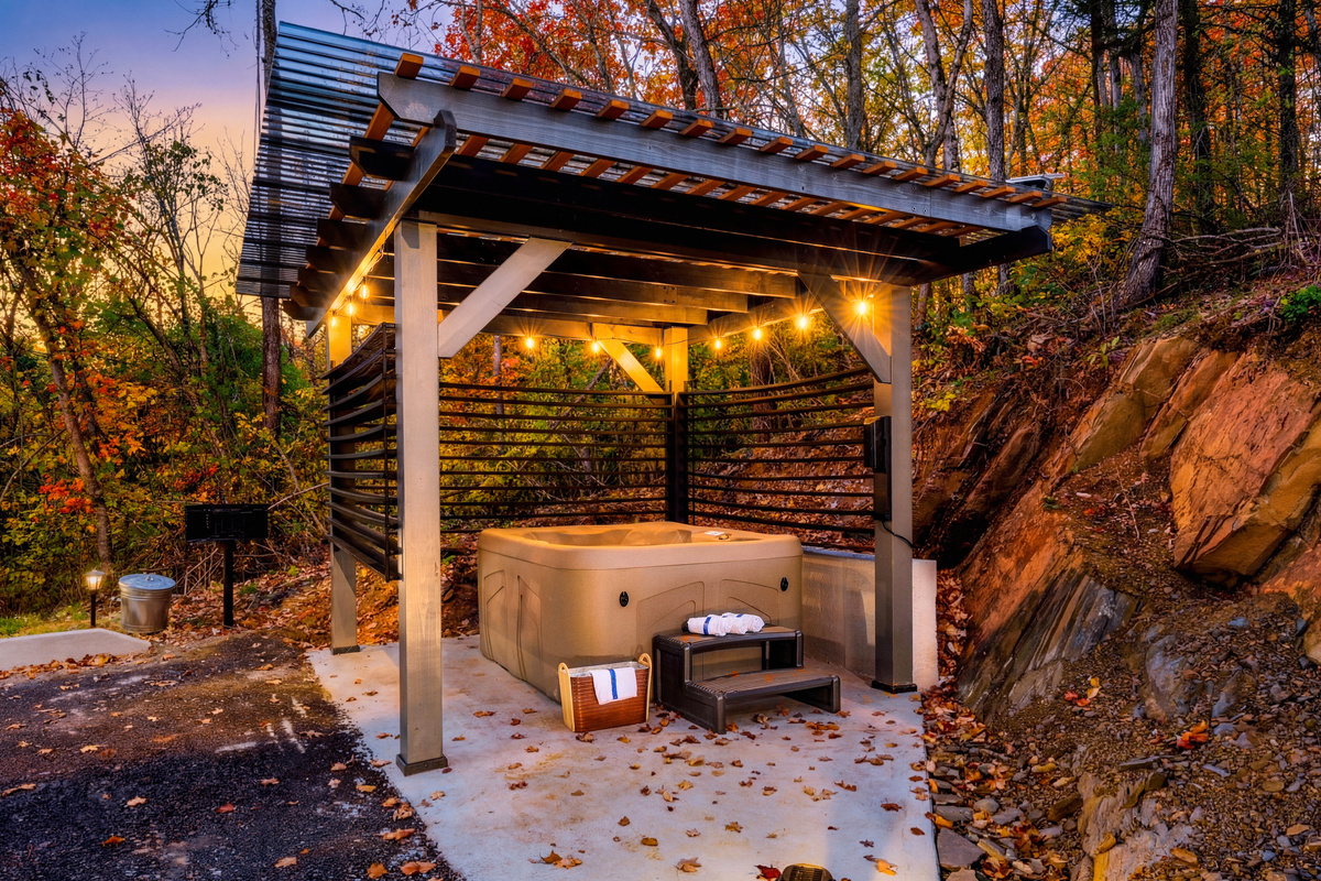 Private outdoor hot tub with pergola and adjustable slats for privacy.  Picnic style BBQ grill on the side.