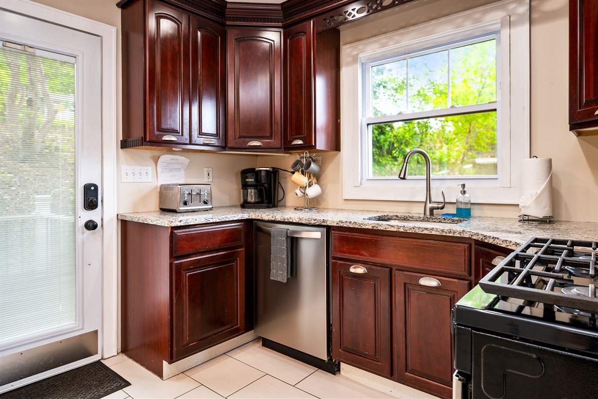 Cook with ease in a well-equipped kitchen featuring rich wood cabinetry and modern appliances 🍳☕🔪