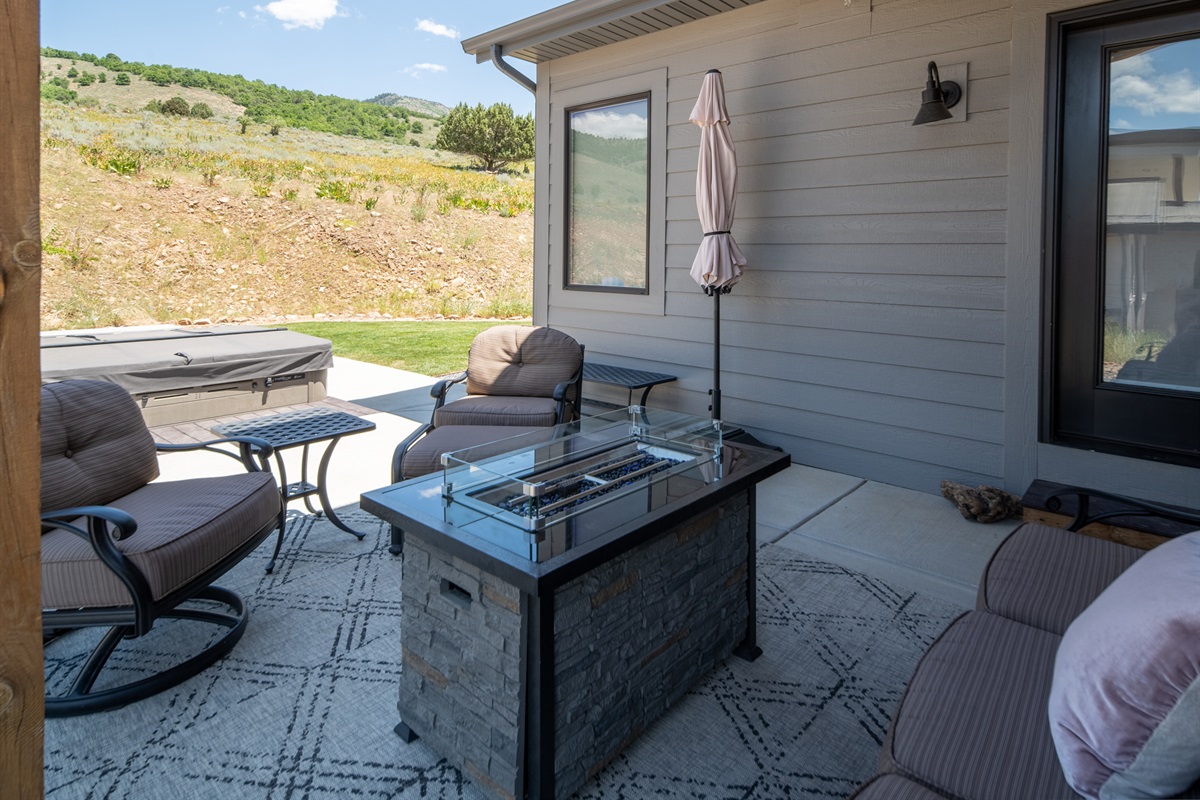 Covered patio lounge with hot tub access and comfortable outdoor seating
