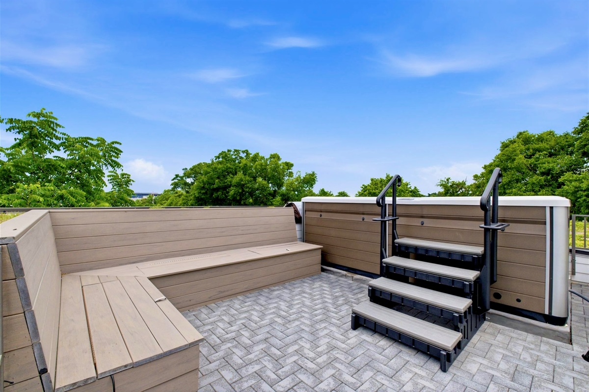 Expansive rooftop deck w/ herringbone tile & open sky — a blank canvas for sunny afternoons.
