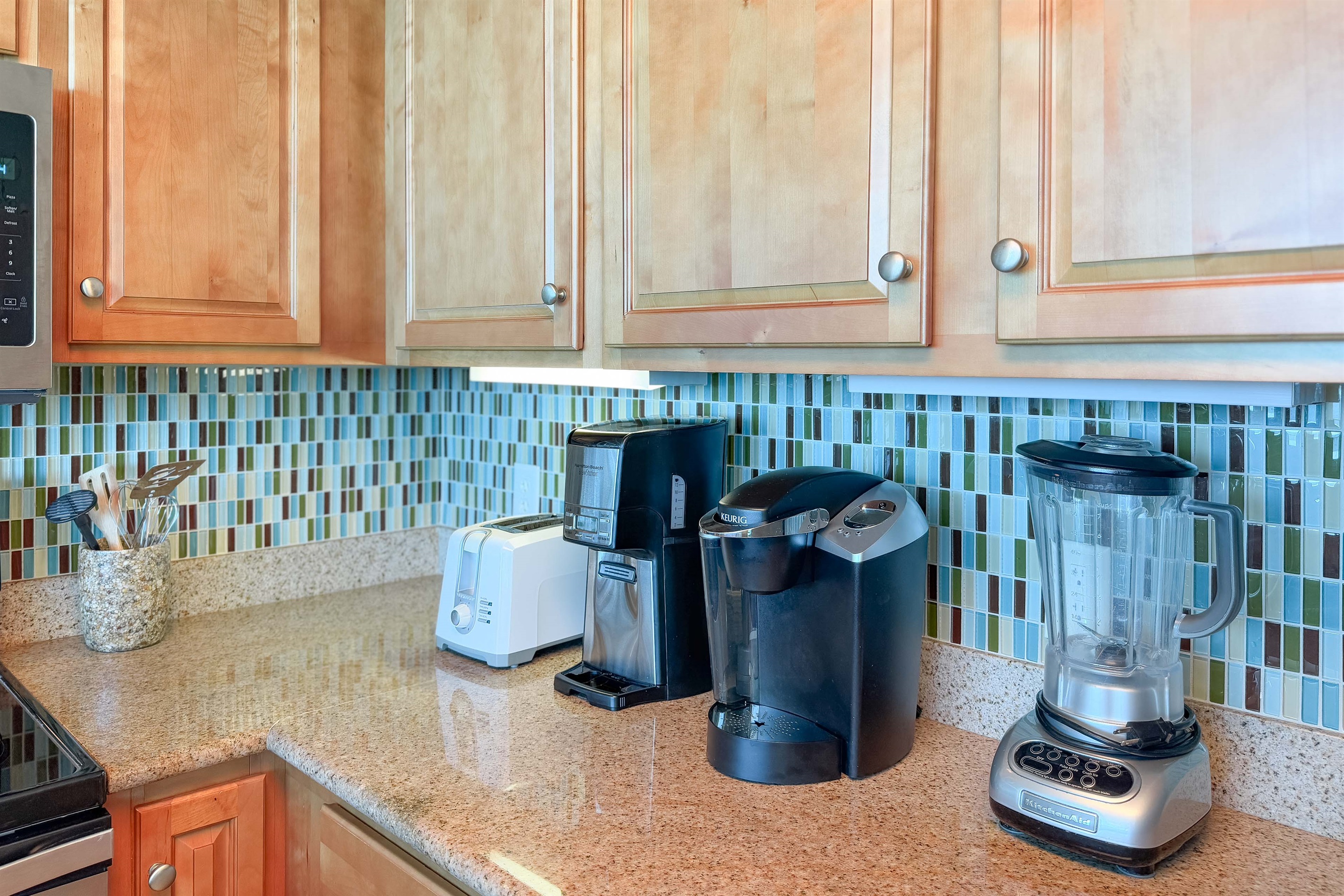 Enjoy your morning brew with both a traditional coffee pot and a single-serve machine, complemented by essential countertop appliances in this well-equipped kitchen.