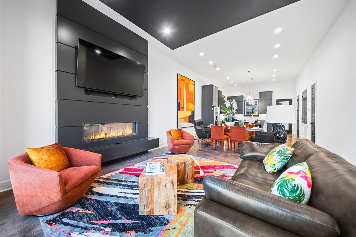 A warm and inviting living space with a cozy fireplace, bold accents, and vibrant colors that make relaxing here a delight.