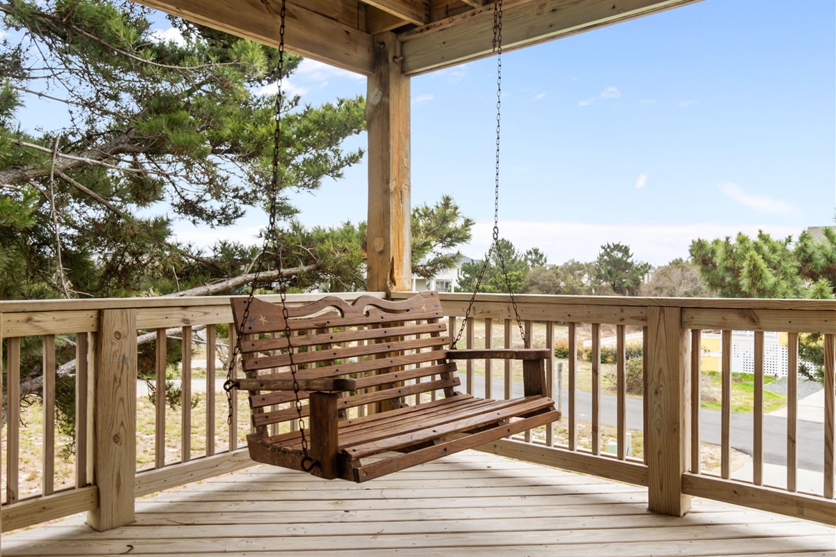 Deck with a wooden swing, perfect for relaxing and enjoying the breeze.