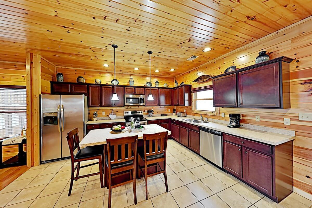 Fully equipped kitchen with island seating for three (no food/drinks provided).