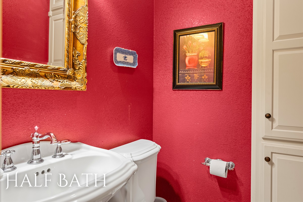 Half bath with bold red walls and classic style.