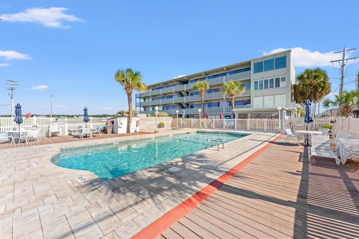 Outdoor pool with loungers and umbrellas on the sundeck