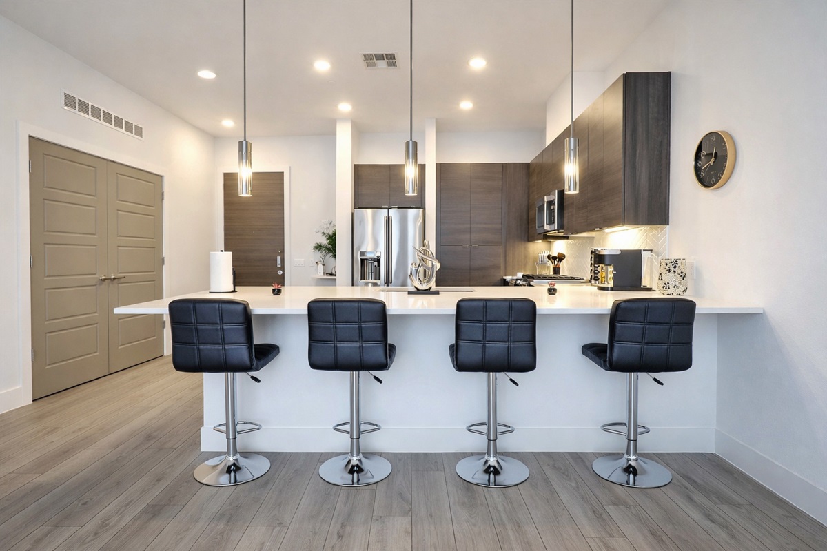 Fully equipped kitchen with spacious counter, modern appliances, and dining chairs for convenient in-kitchen meals or casual dining. Perfect for cooking, gathering, and everyday comfort during your stay.