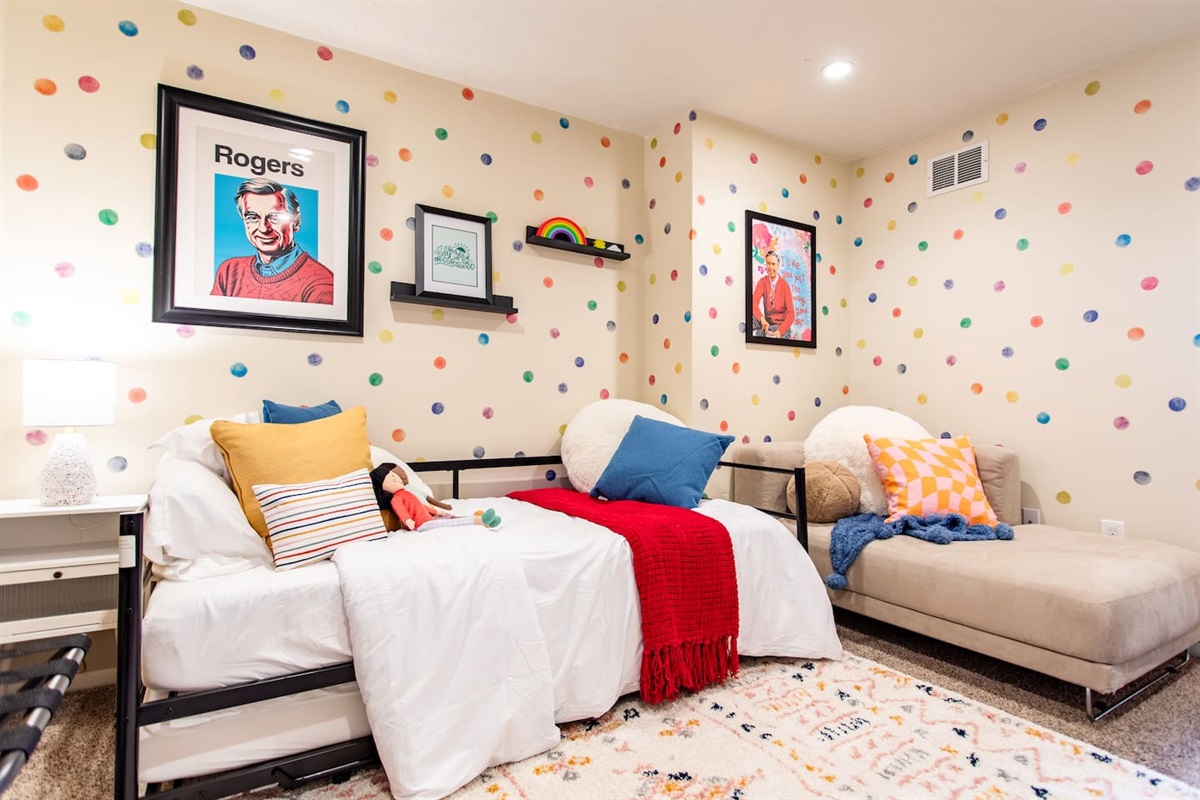 Bright and cheerful bedroom, thoughtfully designed for kids with TV and plenty of natural light and a playful, comfortable atmosphere.